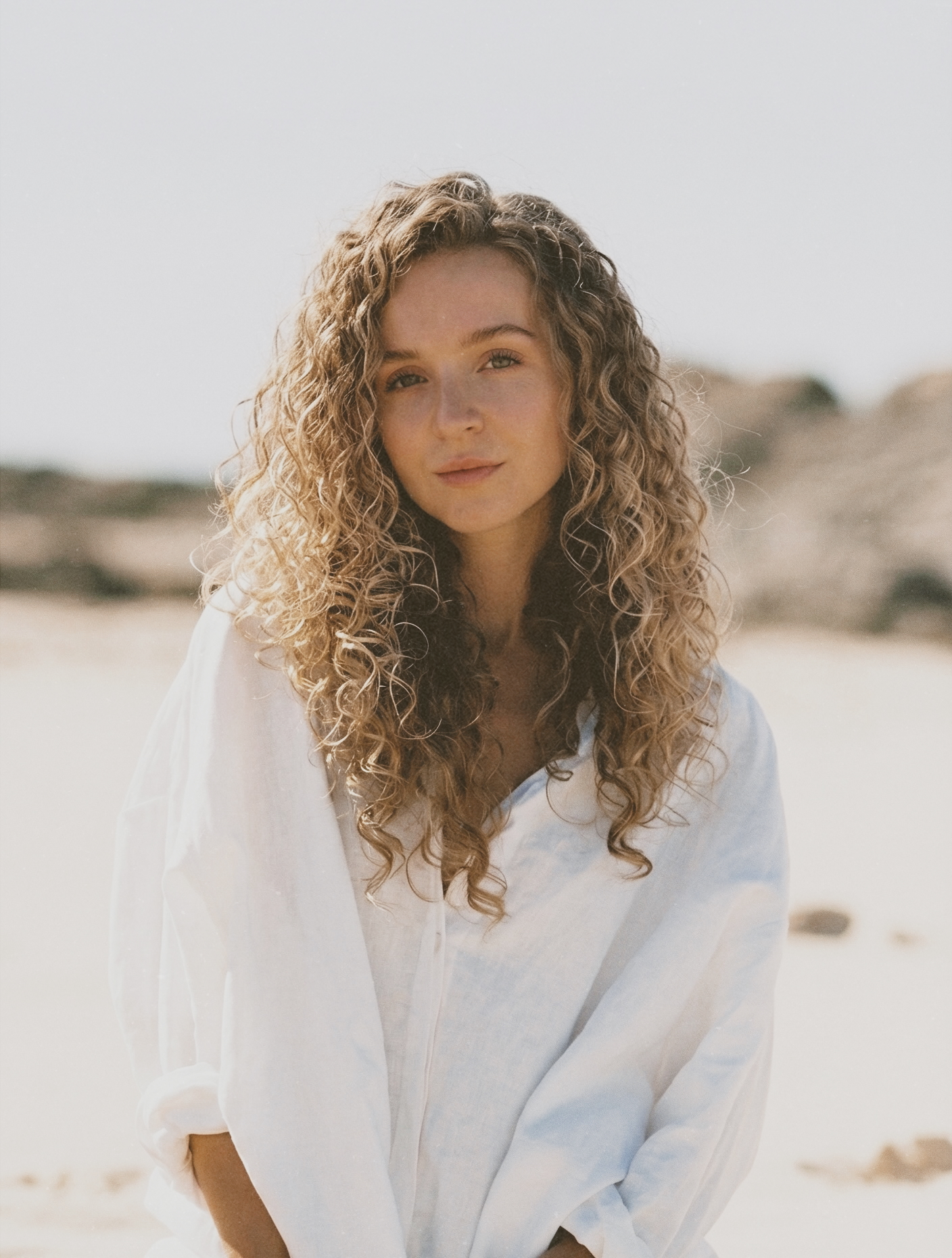 Soft portrait of a woman looking confident and calm in warm lighting